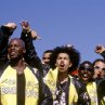 Kid (DEREK LUKE, front left) and Primo (RICK GONZALEZ, front right) and the rest of the Biker Boyz cheer on another racer.